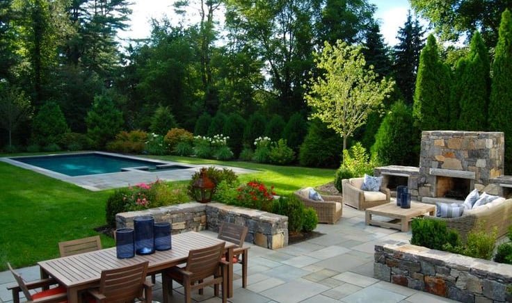 a patio with a table and chairs and a fireplace
